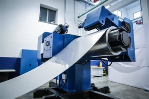 Sheet metal strip unwinding from a Produtech decoiler at the start of a coil-fed profiling flow