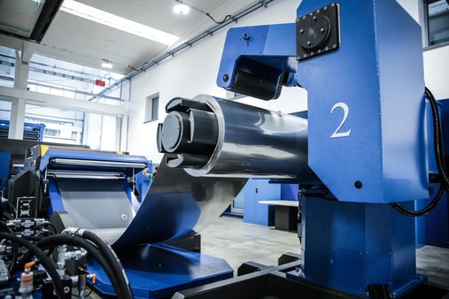 Steel coil mounted on a decoiler, with the sheet metal strip feeding the line